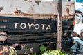 Old rusty cargo truck Toyota Dyna broken front grill with logo closeup view.