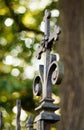 Old rusty Catholic cross on the gate leading to the cemetery. Spider in the corner. Royalty Free Stock Photo