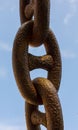 Detail of an old rusty chain on a blue background Royalty Free Stock Photo