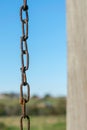 Old rusty chain and chain links, against a natural blue sky and green landscape bokeh background, Block Island, RI Royalty Free Stock Photo