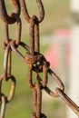 Old rusty chain and chain links, against a natural green bokeh background, close-up, Block Island, RI Royalty Free Stock Photo