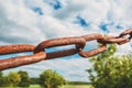 Old rusty chain on the field on the background of the sky Royalty Free Stock Photo