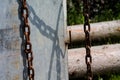 An old rusty chain in front of a steel plate. Royalty Free Stock Photo