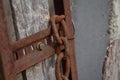 Old rusty chain on a rusty basis on a wall, background or concept, selective focus Royalty Free Stock Photo