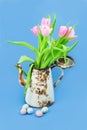 Old rusty coffee maker with tulips on a blue background. Floral concept
