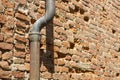 Old rusty copper and cast iron downpipe against a brick wall Royalty Free Stock Photo