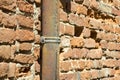 Old rusty copper and cast iron downpipe against a brick wall Royalty Free Stock Photo