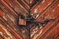 Old rusty corroded padlock with chain on wooden farm barn door Royalty Free Stock Photo