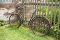 Old rusty damaged bicycle leaning at a wooden fence in a rural area Royalty Free Stock Photo