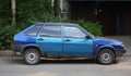 An old rusty dark-blue car with light-blue doors on the road Royalty Free Stock Photo