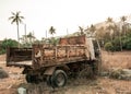 Old rusty destroy car standing in rural tropic place at sunset Royalty Free Stock Photo