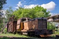 Old rusty diesel locomotive with broken wooden cargo wagon