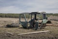 Old rusty dirty abandoned tractor in the field.