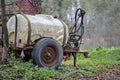 Old rusty dirty useed agricultural plastic tank for water or artificial fertilizers parked in woodlands