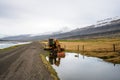 Old and rusty excavator by the side of a gravel road and the river Hamarsa