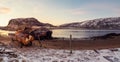 An old rusty fishing boat abandoned by a storm on the shore. Graveyard of ships, old fishing village on the shore of the Barents Royalty Free Stock Photo