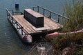 Old rusty floating platform with wooden floor and bench in the middle, serving as molo in yacht club. Royalty Free Stock Photo