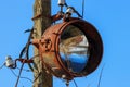 Old rusty floodlight mounted on a support of electricity transmissions Royalty Free Stock Photo