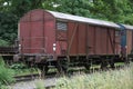 Old rusty freight wagon on the siding on overgrown railroad tracks, transportation concept, copy space Royalty Free Stock Photo