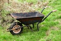 Old rusty garden cart on green grass. Spring garden work Royalty Free Stock Photo