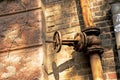 Old rusty gas control valve on the wall. The gas transmission system of Ukraine is failing Royalty Free Stock Photo