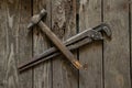 Old rusty gas wrench and hammer lie on a wooden table close up Royalty Free Stock Photo