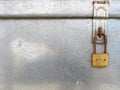 old rusty golden padlock with blank sign hanging with metallic hinge for lock on aluminum chest box cover