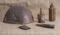 Old rusty grenades, cartridges and a helmet of the second world war on the fabric. Closeup Royalty Free Stock Photo