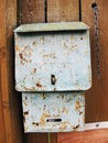 Old rusty grey postbox on wooden wall