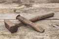 old hammer and rusty chisel on a wooden unpainted workbench