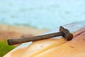 Old rusty hammer rests on the plastic hull of the boat in the background of the water Royalty Free Stock Photo