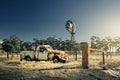 Old rusty Holden FJ Ute and old windmill