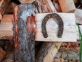 Old rusty horse shoe on a big wooden log. Symbol on luck in a country setting. Rural theme Royalty Free Stock Photo