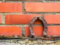 Old rusty horse shoe on a red color brick wall. Symbol on luck in a country setting. Rural theme Royalty Free Stock Photo