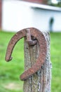 Old Rusty Horseshoe Hanging On An Old Weathered Fencepost.