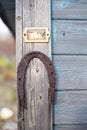 An old rusty horseshoe hangs nailed to the wall of an old wooden house Royalty Free Stock Photo