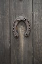 Old rusty horseshoe nailed to a front wooden door close