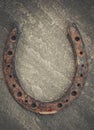 Old rusty horseshoe on natural stone background. Royalty Free Stock Photo