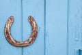 Old rusty horseshoe on wooden blue background. Royalty Free Stock Photo