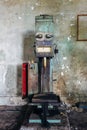 Old rusty industrial drilling machine in abandoned factory workshop looks like robot Royalty Free Stock Photo