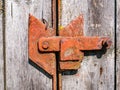 Old rusty iron bolt of a wooden gate lock