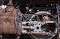 Old rusty iron cylinder and driving rods on a steam engine