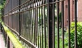 Old rusty iron fence beside the road close up with selective focus Royalty Free Stock Photo