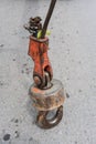 Old and rusty iron hook standing on concrete floor Royalty Free Stock Photo