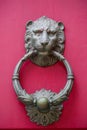 Old golden iron lion head door knocker on a wooden pink door. Mdina, Malta Royalty Free Stock Photo