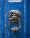 Old rusty iron lion head door knocker on a wooden azure door. Mdina, Malta Royalty Free Stock Photo