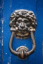 Old rusty iron lion head door knocker on a wooden azure door. Mdina, Malta Royalty Free Stock Photo