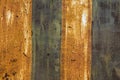 Old rusty iron metal sheet with peeling yellow and blue paint. vertical stripes. rough surface texture Royalty Free Stock Photo