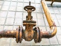 Old rusty iron pipe and control valve on house wall Royalty Free Stock Photo