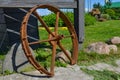 Old rusty iron wheel on a green field Royalty Free Stock Photo